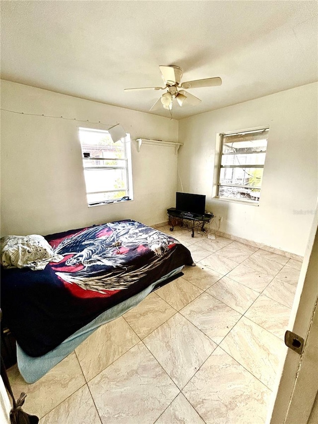 bedroom featuring multiple windows and ceiling fan