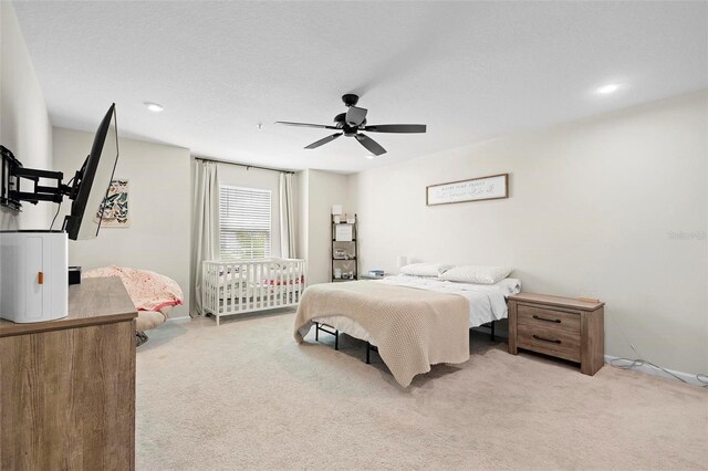 carpeted bedroom featuring a textured ceiling and ceiling fan