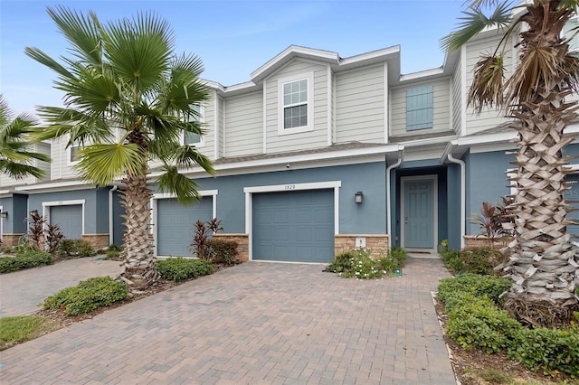 1820 Holden Ridge Ln, Clermont, FL 34715 - townhome / multi-family property with decorative driveway, an attached garage, and stucco siding
