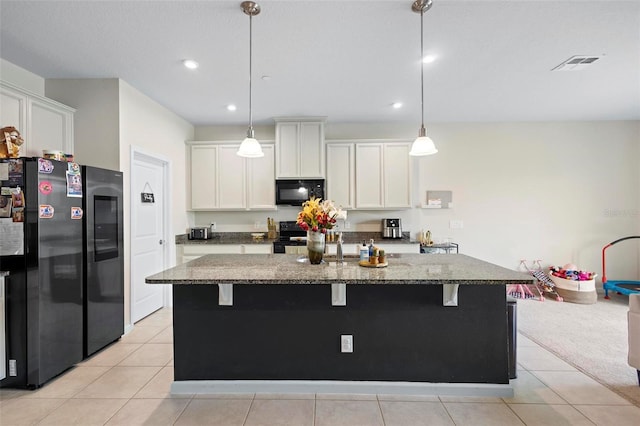 1820 Holden Ridge Ln, Clermont, FL 34715 - kitchen with visible vents, black appliances, a center island with sink, dark stone countertops, and white cabinets