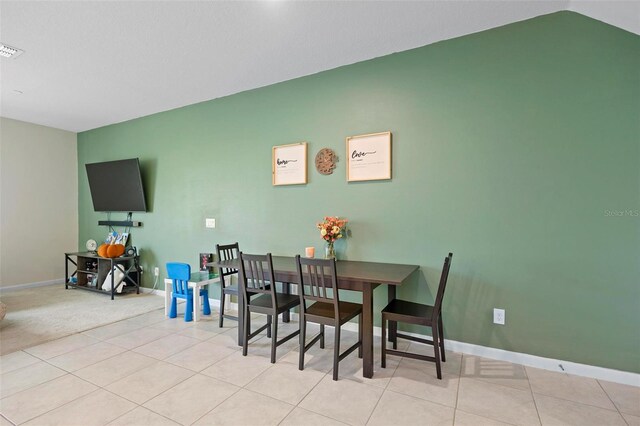 dining space featuring lofted ceiling and light tile patterned flooring