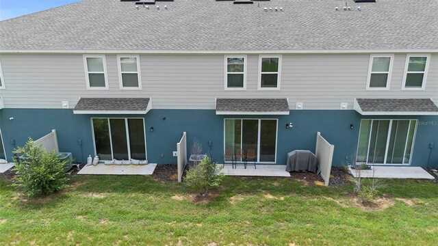 rear view of property with a yard and a patio area