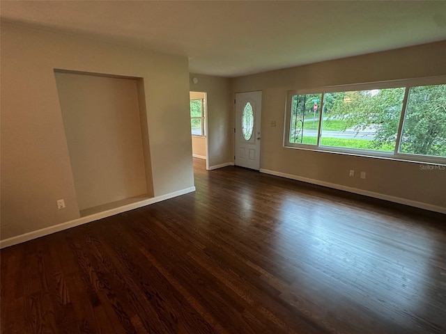 unfurnished room with dark wood-type flooring