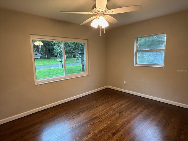 empty room with dark wood-type flooring and ceiling fan