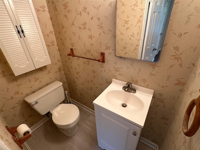 bathroom with hardwood / wood-style floors, toilet, and vanity