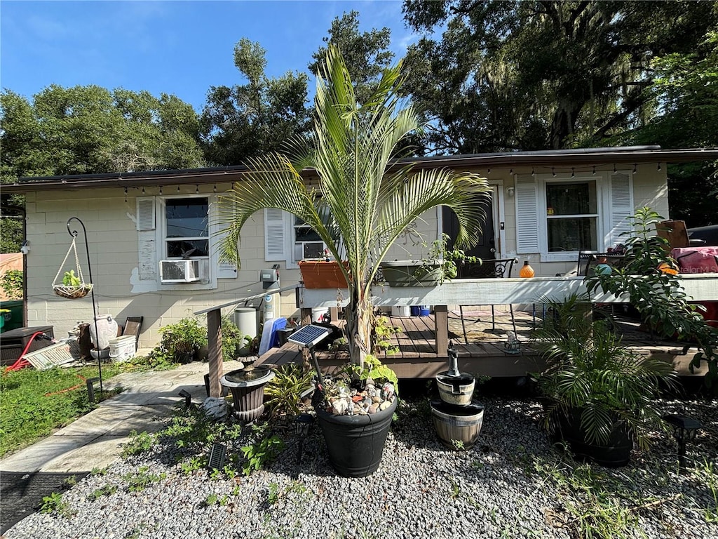 back of property with a wooden deck and cooling unit