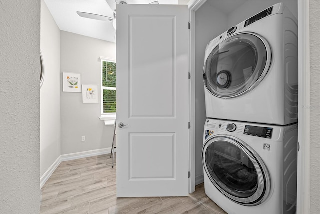 washroom featuring light hardwood / wood-style flooring, ceiling fan, and stacked washing maching and dryer