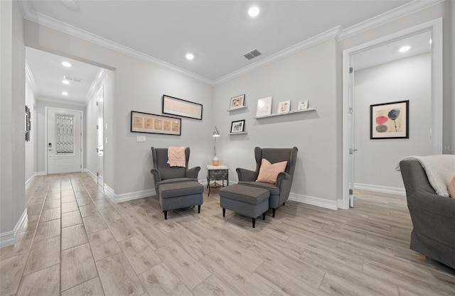 living area with crown molding and light hardwood / wood-style flooring