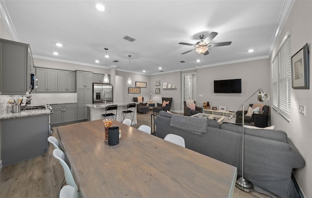 dining area featuring crown molding, ceiling fan, and light hardwood / wood-style floors