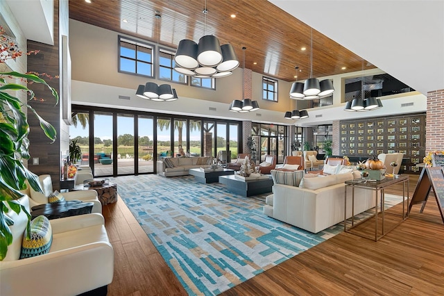 living room featuring wood ceiling, a towering ceiling, and hardwood / wood-style floors