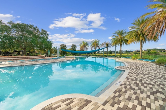 view of swimming pool featuring a water slide and a patio