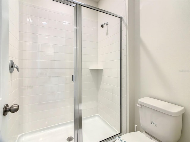 bathroom with toilet and an enclosed shower