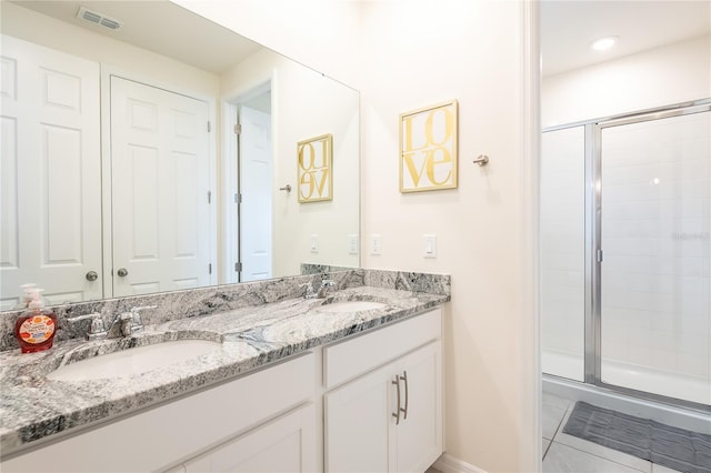 bathroom featuring tile patterned floors, a shower with shower door, and vanity