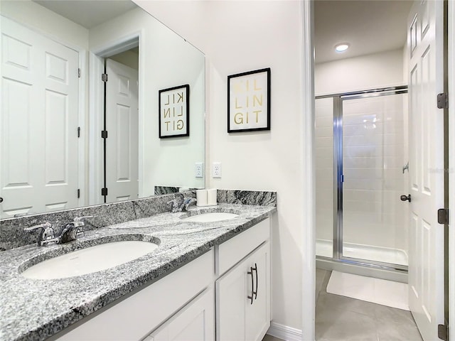 bathroom featuring vanity, a shower with shower door, and tile patterned floors