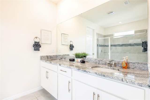 bathroom featuring tile patterned flooring, vanity, and walk in shower