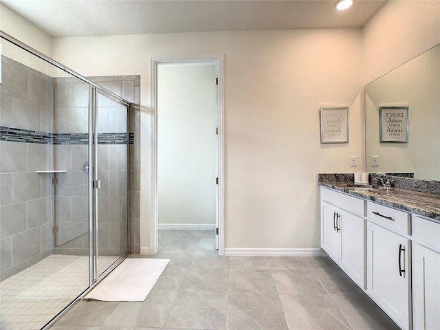 bathroom featuring a shower with shower door, tile patterned flooring, and vanity