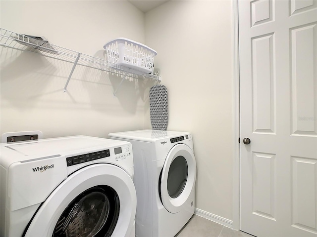 laundry area featuring light tile patterned floors and washer and clothes dryer