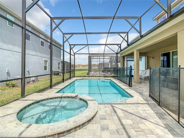 view of pool with glass enclosure, an in ground hot tub, and a patio