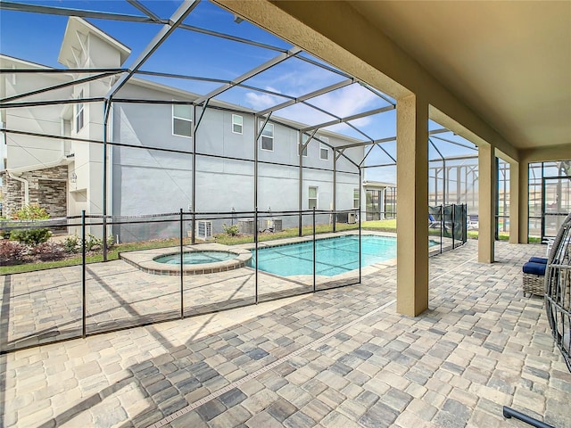 view of pool with a patio, a lanai, and an in ground hot tub