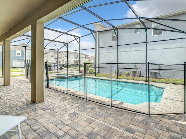 view of swimming pool with glass enclosure and a patio