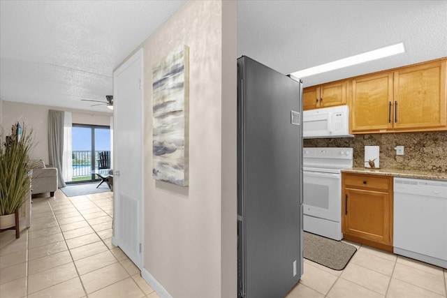 kitchen featuring white appliances, light tile patterned floors, a textured ceiling, and ceiling fan