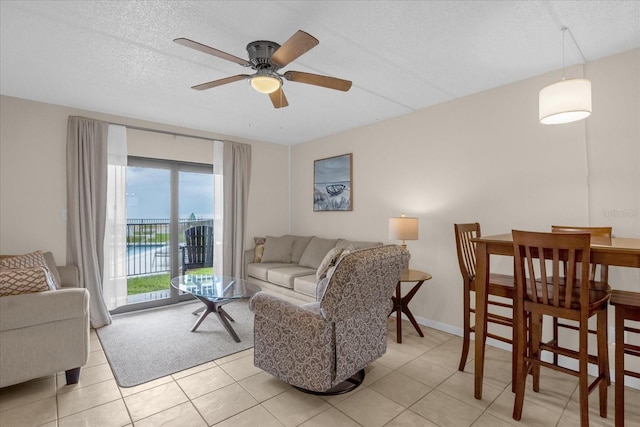 tiled living room with a textured ceiling and ceiling fan