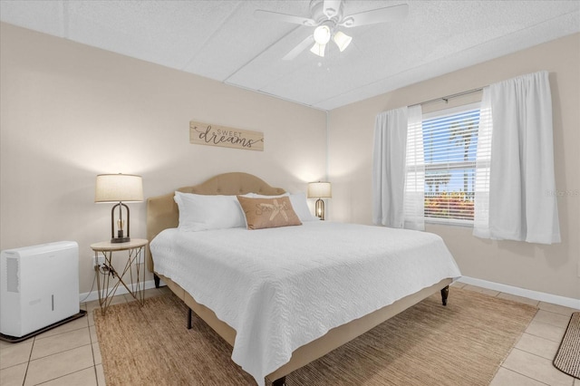 tiled bedroom with a textured ceiling and ceiling fan