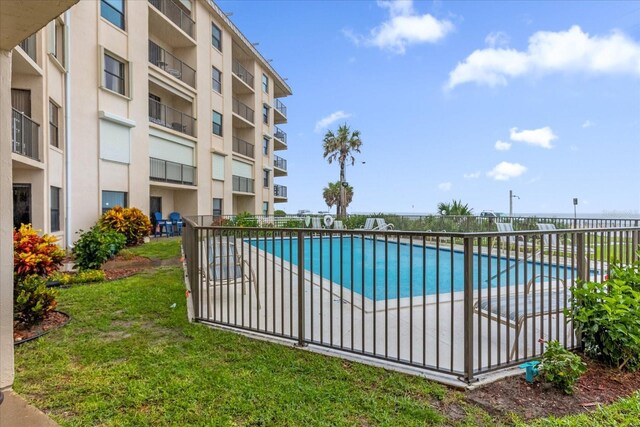 view of pool with a lawn