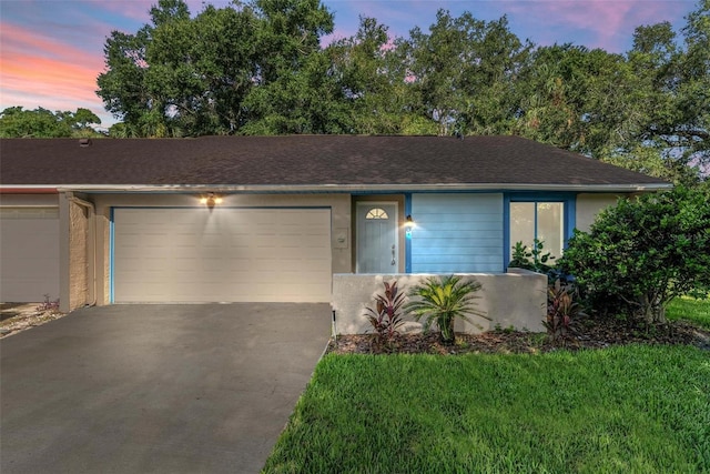 ranch-style house with a lawn and a garage