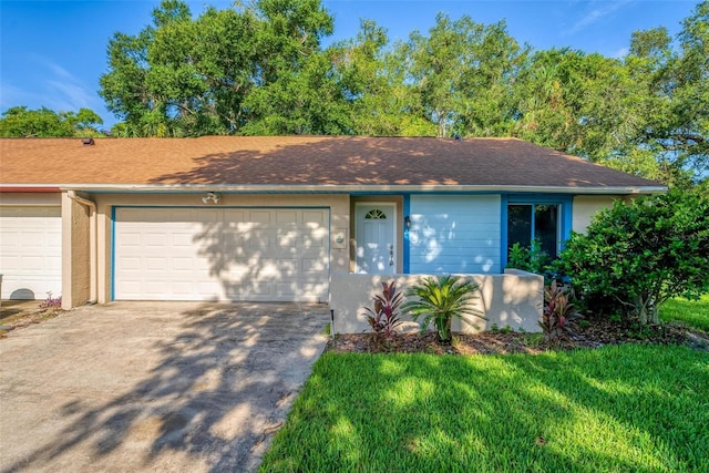 ranch-style house featuring a garage and a front lawn