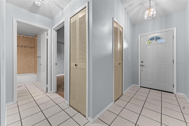 tiled foyer with a notable chandelier and a textured ceiling