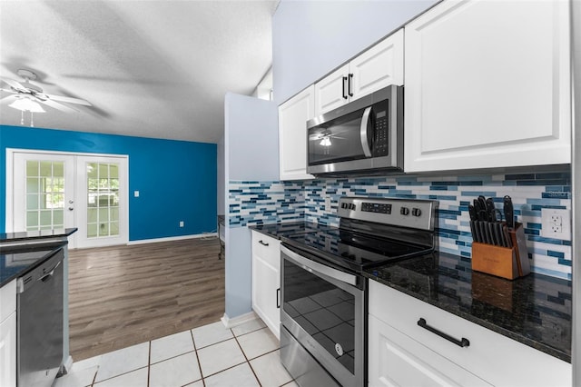 kitchen featuring light wood-type flooring, stainless steel appliances, white cabinetry, ceiling fan, and tasteful backsplash