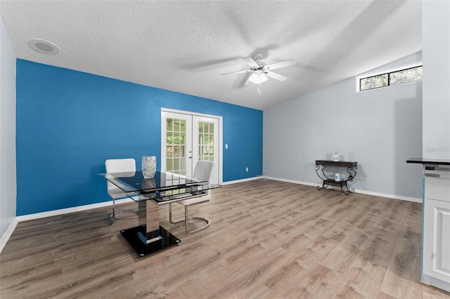 unfurnished office featuring a wealth of natural light, ceiling fan, light wood-type flooring, and french doors