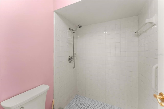 bathroom featuring toilet and a tile shower