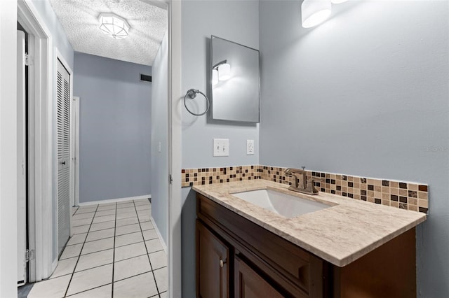 bathroom with vanity, a textured ceiling, decorative backsplash, and tile patterned flooring