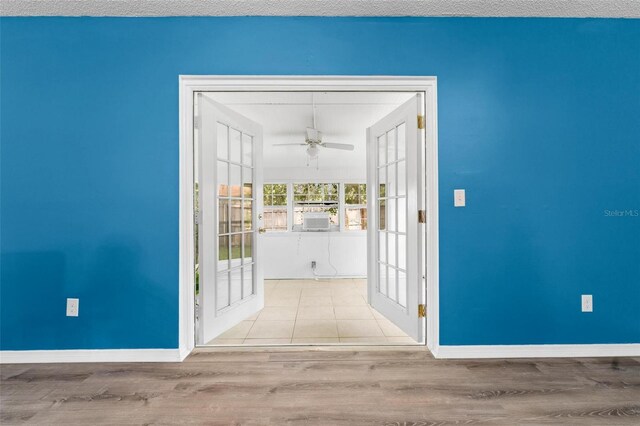 corridor featuring light wood-type flooring and a textured ceiling