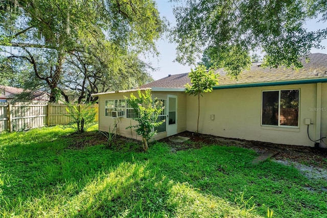 108 Clear Lake Cir, Sanford, FL 32773 - rear view of property with stucco siding, a shingled roof, fence, and a yard