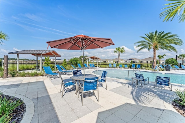 view of patio / terrace with a community pool and fence