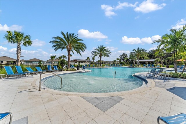 pool with a patio and fence