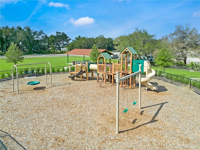 community jungle gym with a lawn and fence