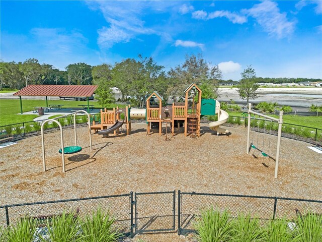 community play area with a lawn and fence