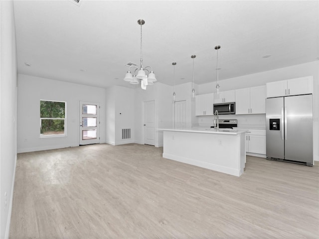 kitchen with light countertops, white cabinets, light wood-type flooring, and stainless steel appliances