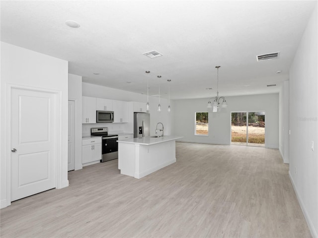 kitchen with light hardwood / wood-style floors, white cabinetry, stainless steel appliances, and a center island with sink