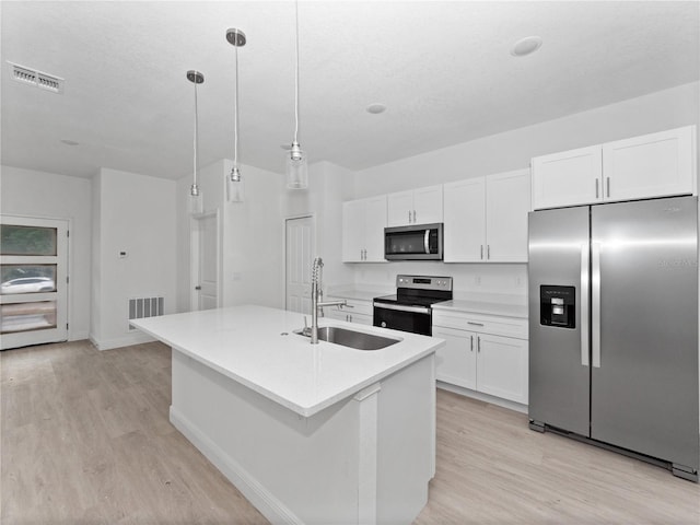 kitchen with visible vents, light wood-type flooring, stainless steel appliances, white cabinetry, and a sink