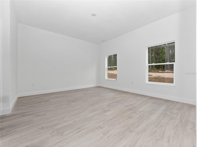 empty room featuring baseboards and light wood-style flooring