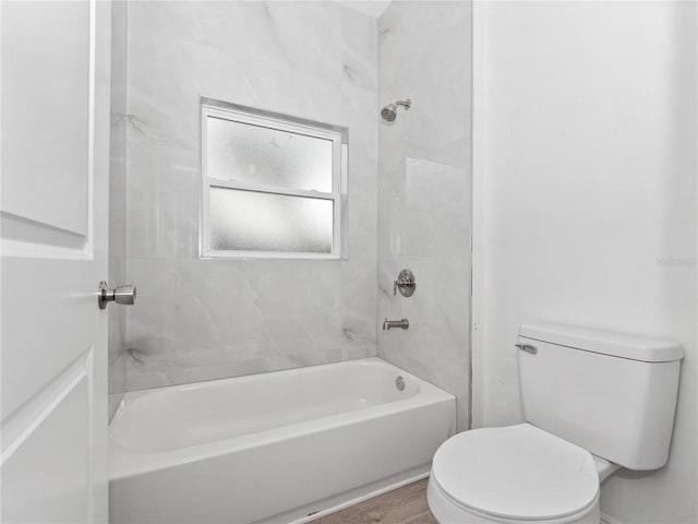 full bathroom with washtub / shower combination, toilet, and wood finished floors