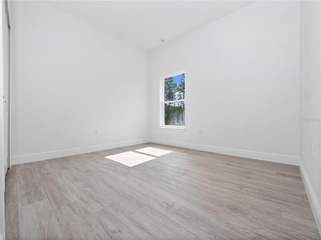 unfurnished room featuring baseboards and light wood-style flooring