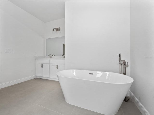 bathroom featuring tile patterned flooring, a bathing tub, and vanity