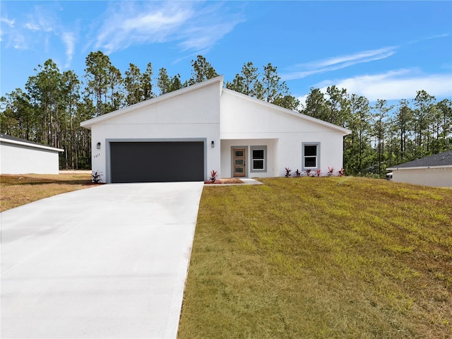 mid-century inspired home with a garage, stucco siding, driveway, and a front lawn