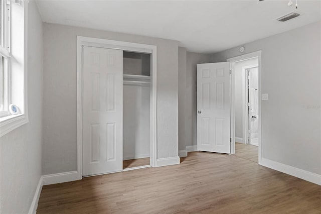 unfurnished bedroom featuring light wood-type flooring and a closet